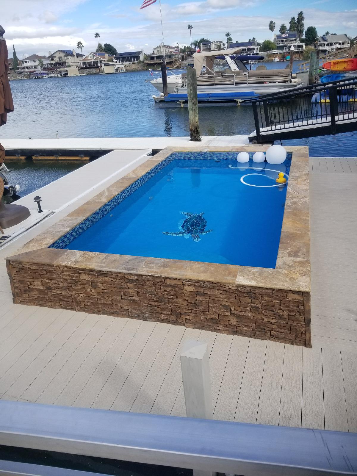 A modern, in-ground pool in a residential backyard setting, exuding a relaxing resort-like feel amidst a warm climate. The neutral tone and natural vibrancy create a serene ambiance, perfect for any season.