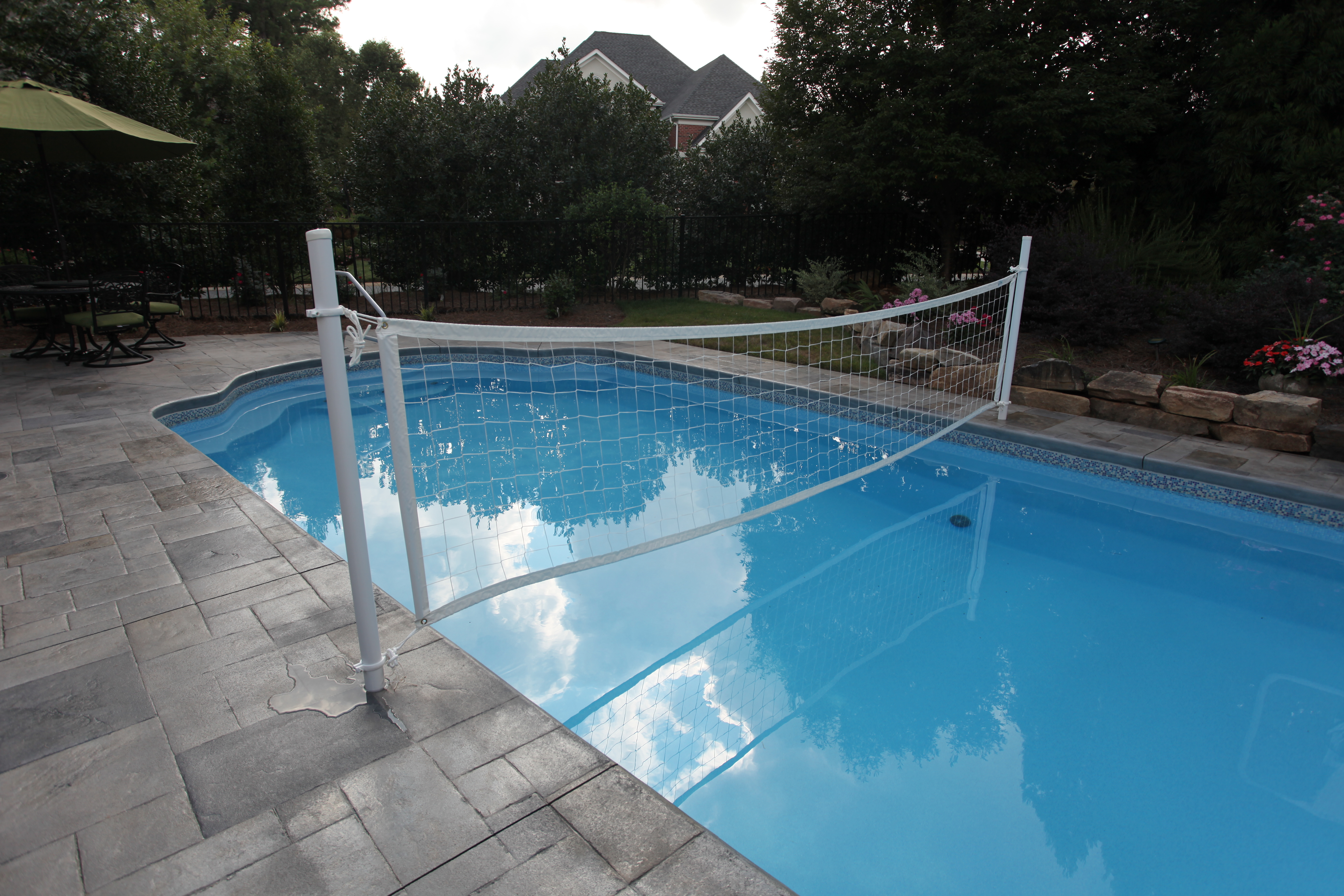 Enjoy endless summer fun with this pristine fiberglass pool set in a tranquil backyard, complete with a stone deck and vibrant landscaping.