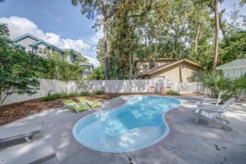 Fiberglass freeform pool in a landscaped backyard.