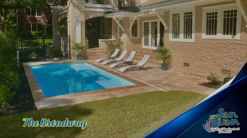 Fiberglass inground pool with turquoise water in a backyard