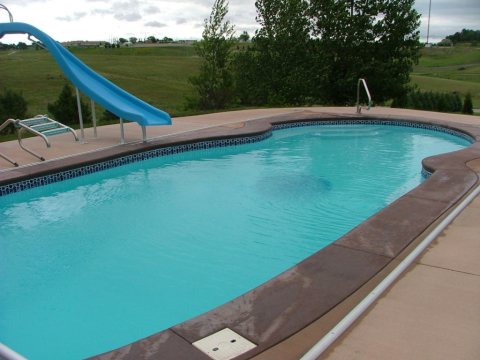 Fiberglass pool with turquoise water in a backyard setting