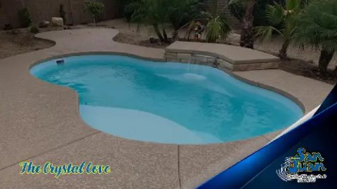 Finished freeform fiberglass pool with clear turquoise water and tanning ledge in a backyard
