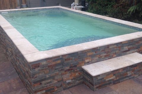 San Juan fiberglass pool with clear turquoise water and mosaic tile shell in a backyard
