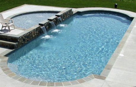 San Juan fiberglass pool with spa and waterfall in a sunny backyard